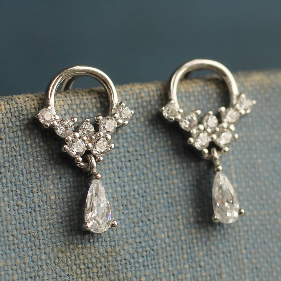 A pair of elegant silver earrings with dangling crystal pendants.