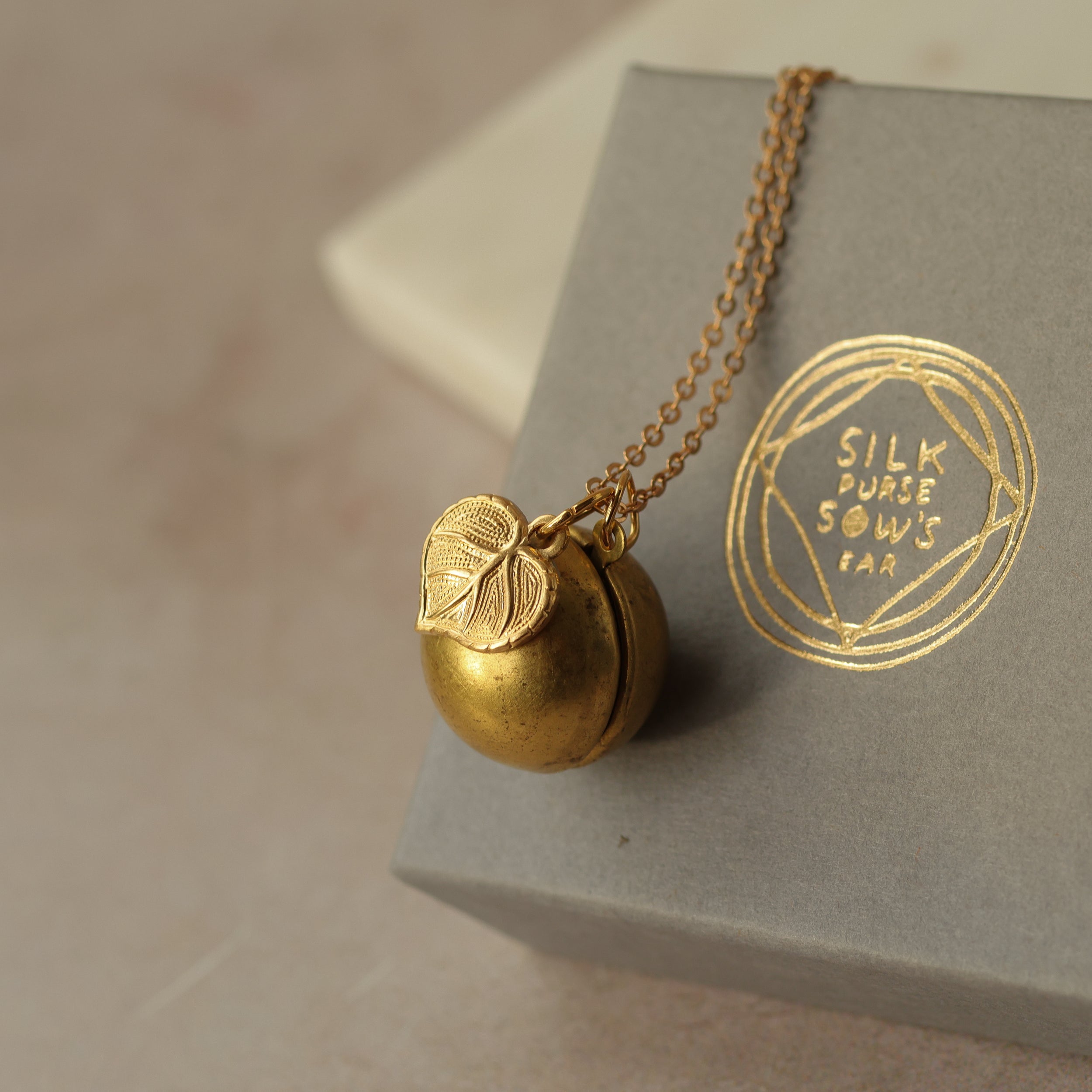 Gold Brass Sphere Locket with Tiny Leaf