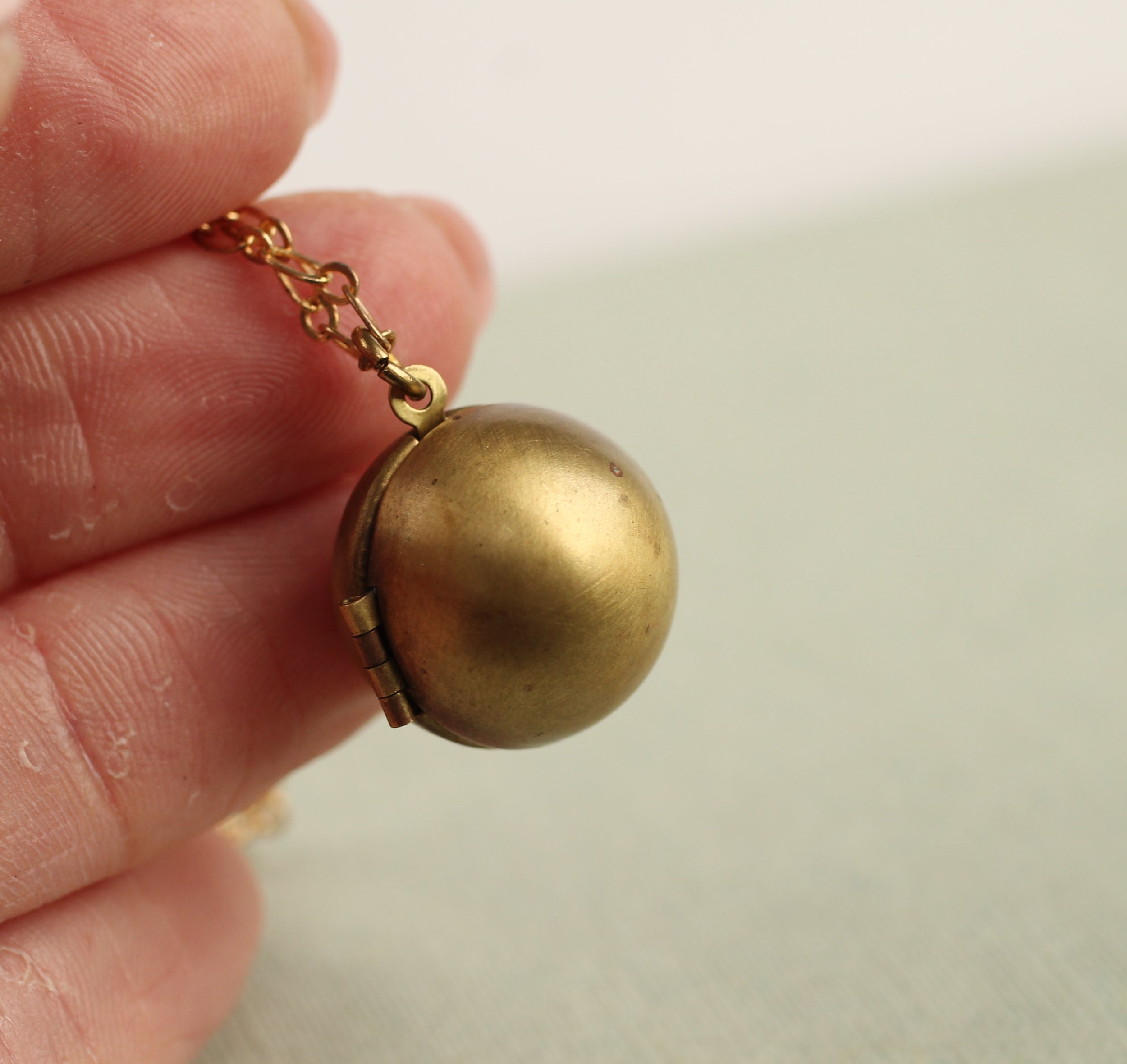 Gold Brass Sphere Locket with Tiny Leaf