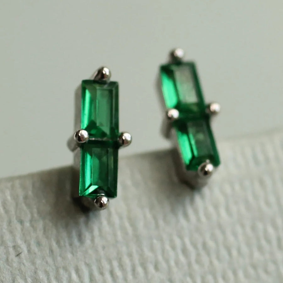 A pair of green rectangular earrings with silver posts and gemstones.