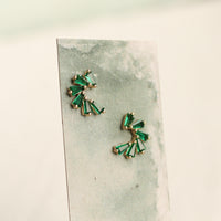 two pieces of earrings with green gemstones, displayed on a grey background.